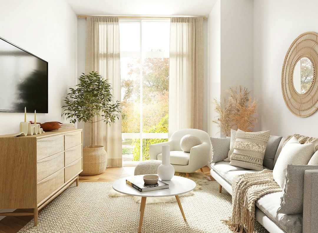 Lyst oppholdsrom med store vinduer, planter og naturlig dagslys